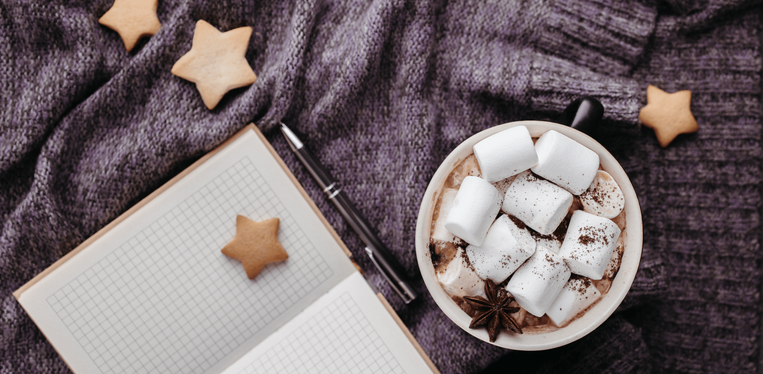 A cup of hot chocolate with marshmallows, a notebook and a pen - Marshmallows