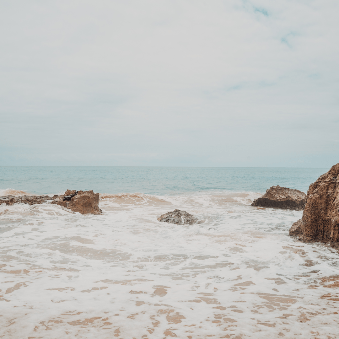 A photo of a rocky beach with the ocean crashing against the rocks. - Balance