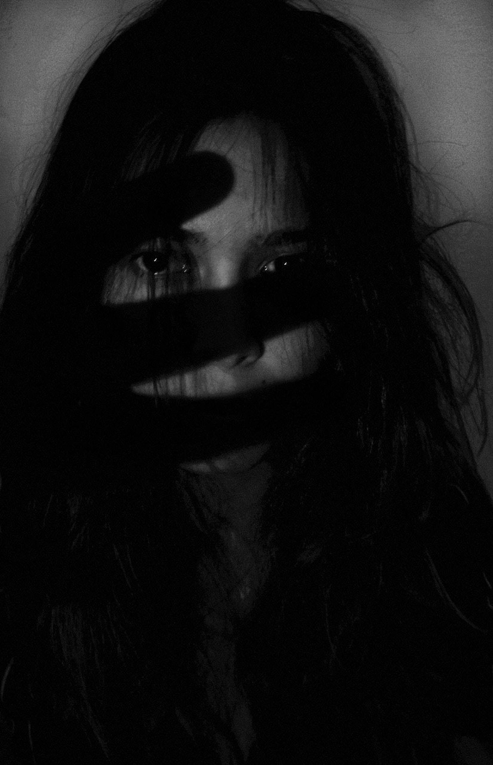 A woman with long hair is partially obscured by a black and white photo of a hand. - Depression