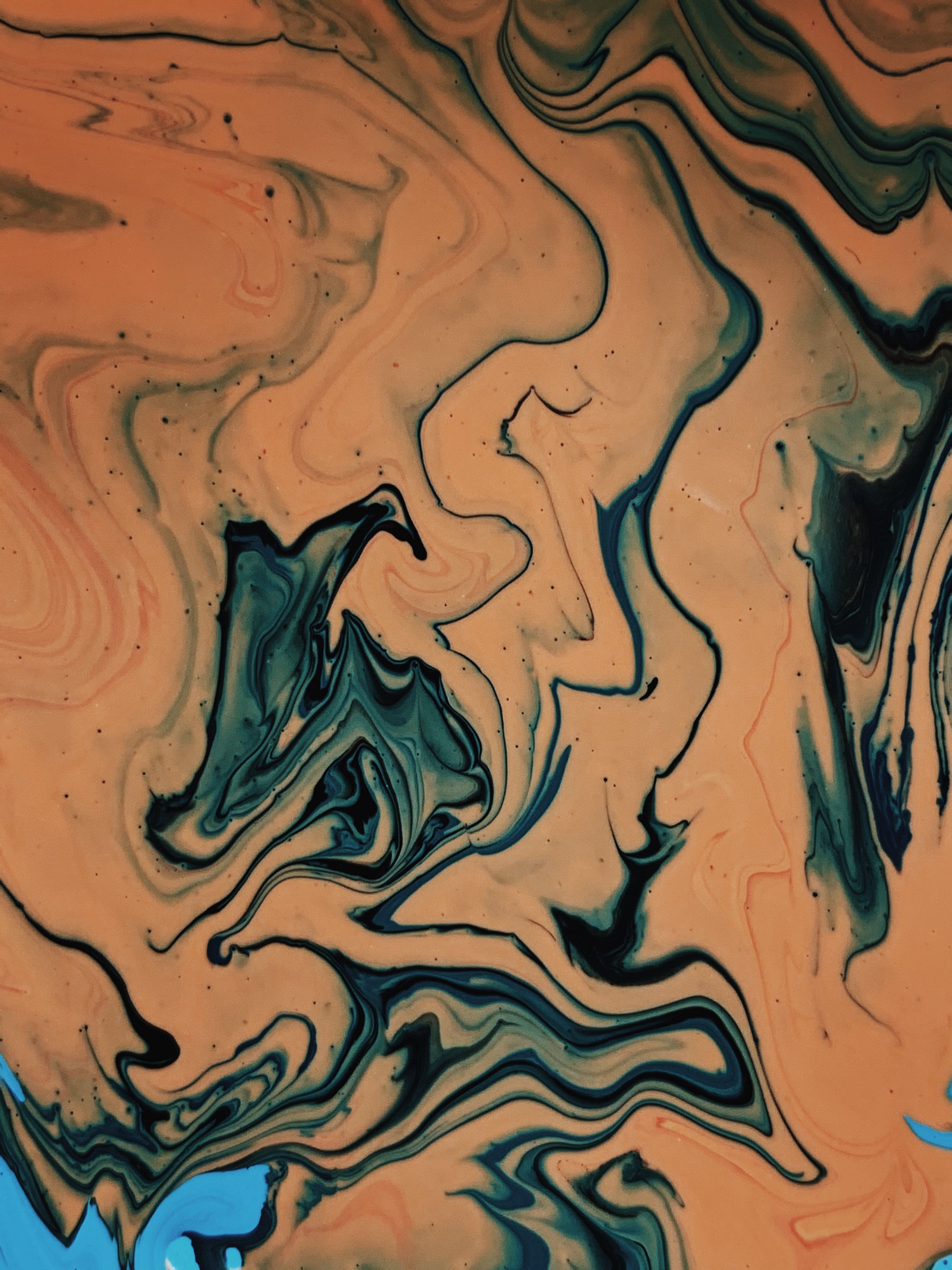 A close up of an orange and blue liquid - Brown