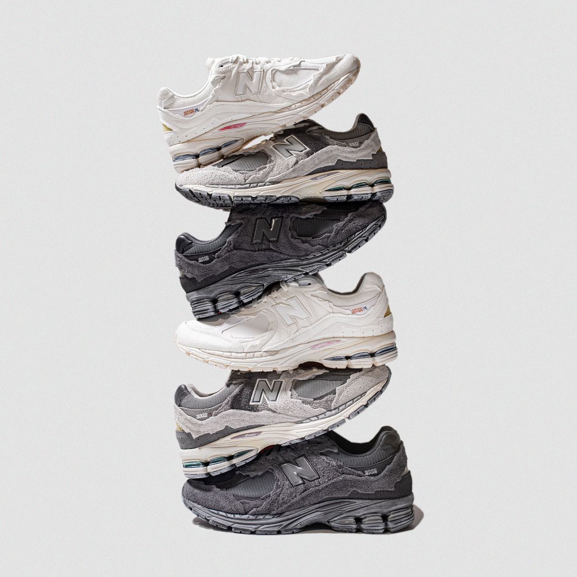 A stack of 6 New Balance 2002R sneakers in different colors. - New Balance