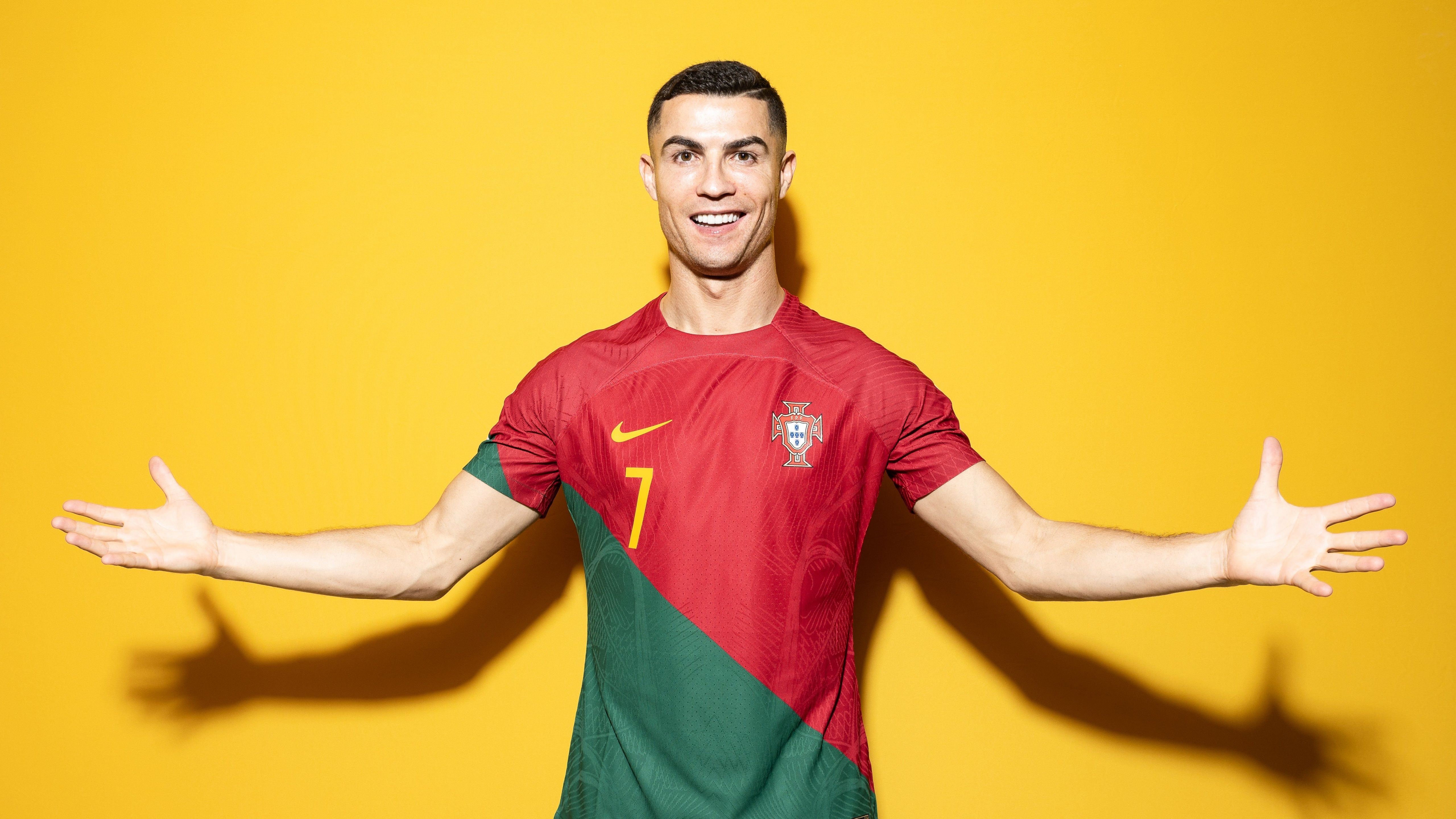 Cristiano Ronaldo wearing the Portugal home jersey, standing in front of a yellow background - Cristiano Ronaldo