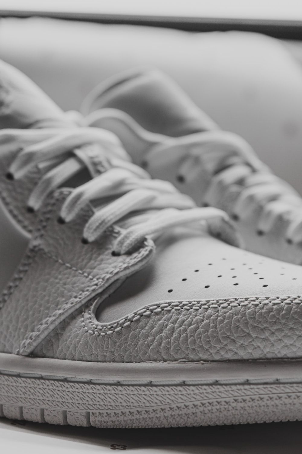 A pair of white sneakers with a textured toe cap - Air Jordan