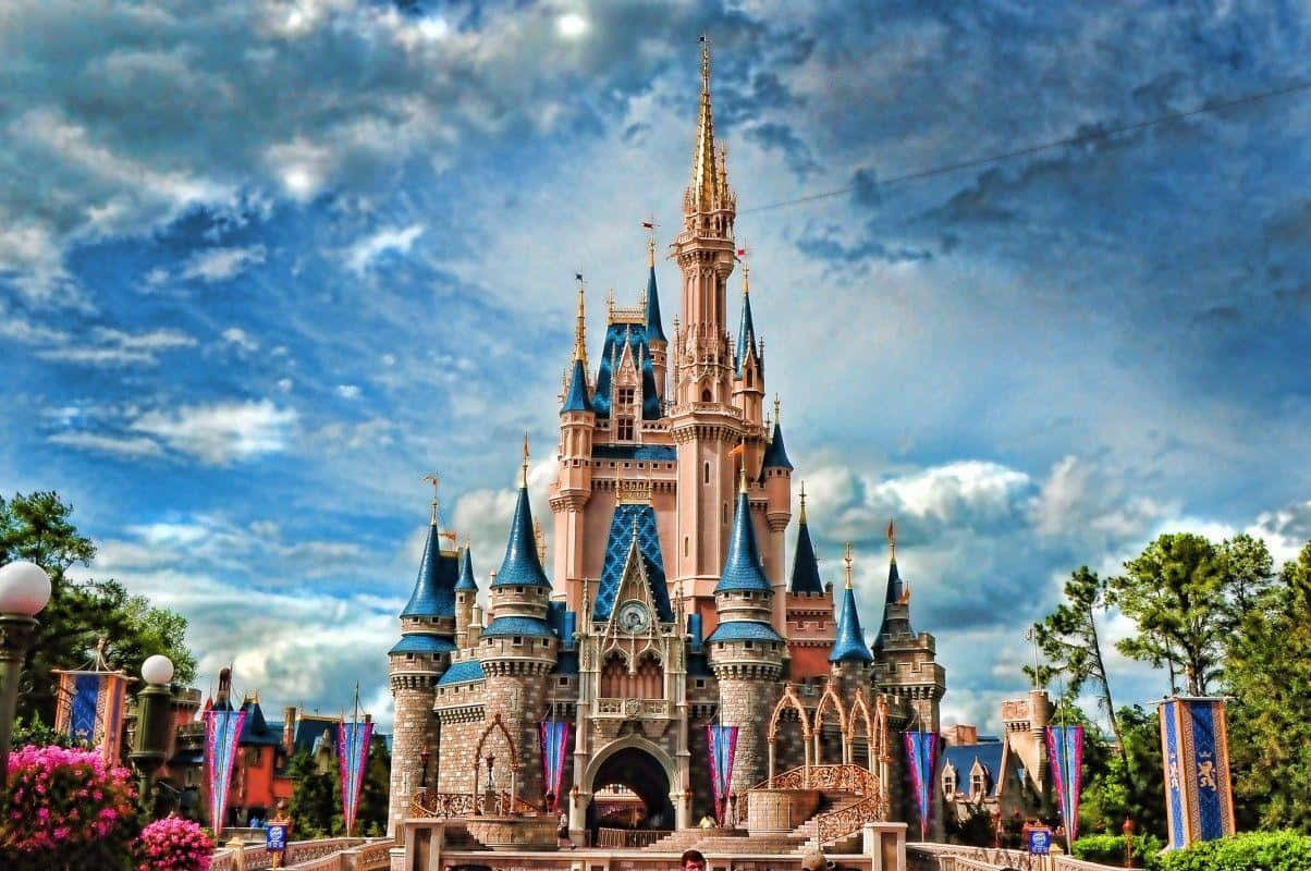 The castle at Disney World in Florida, with a blue sky and fluffy white clouds in the background. - Disneyland