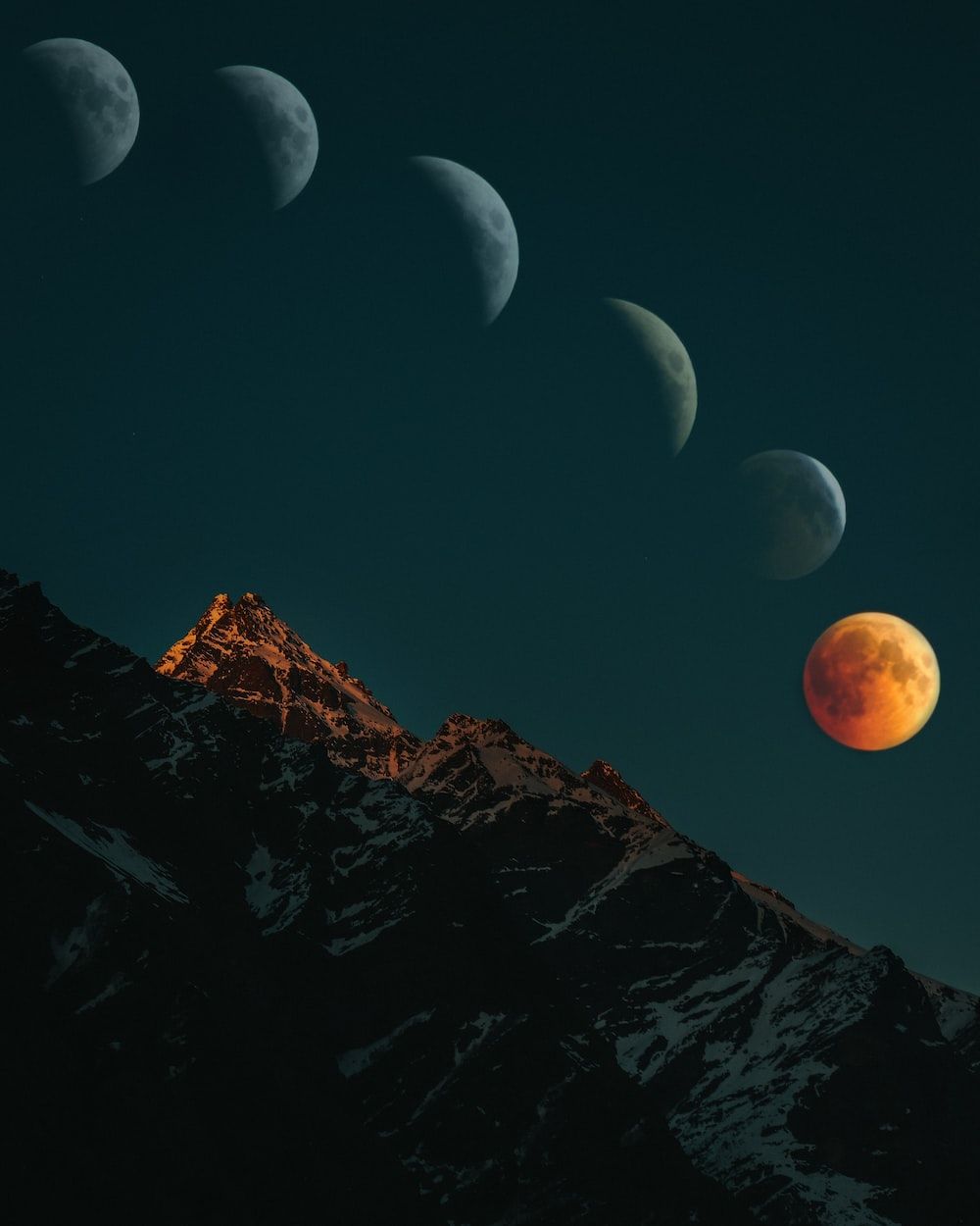 Four phases of the moon with a mountain in the background. - Eclipse