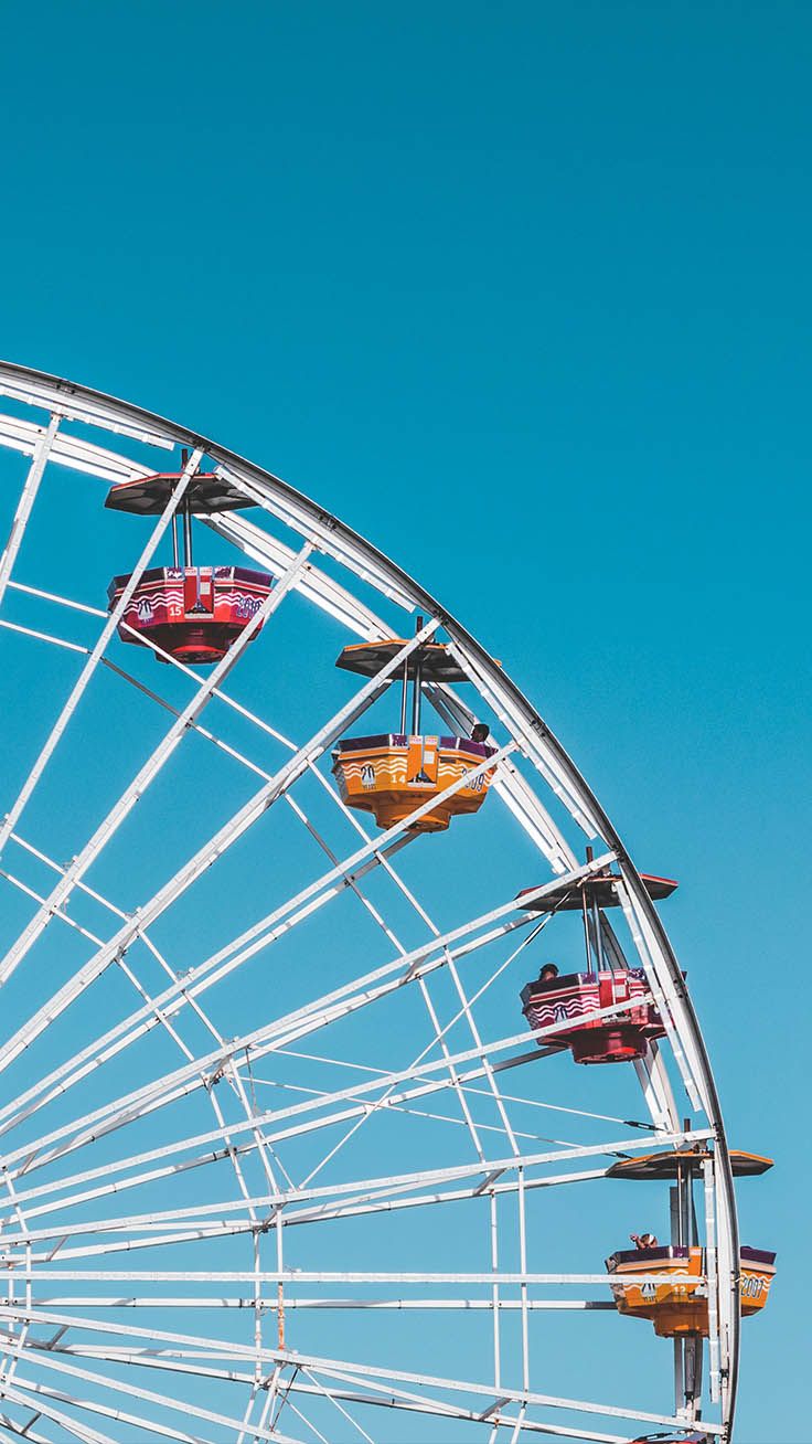 A colorful ferris wheel with blue sky in the background - Preppy