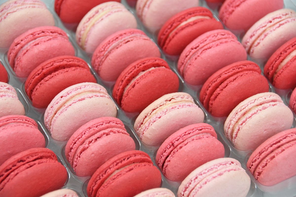 A tray of pink and red macarons - Macarons