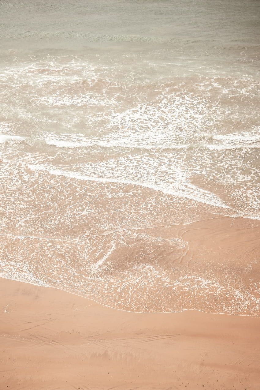 A sandy beach with a body of water - Sand