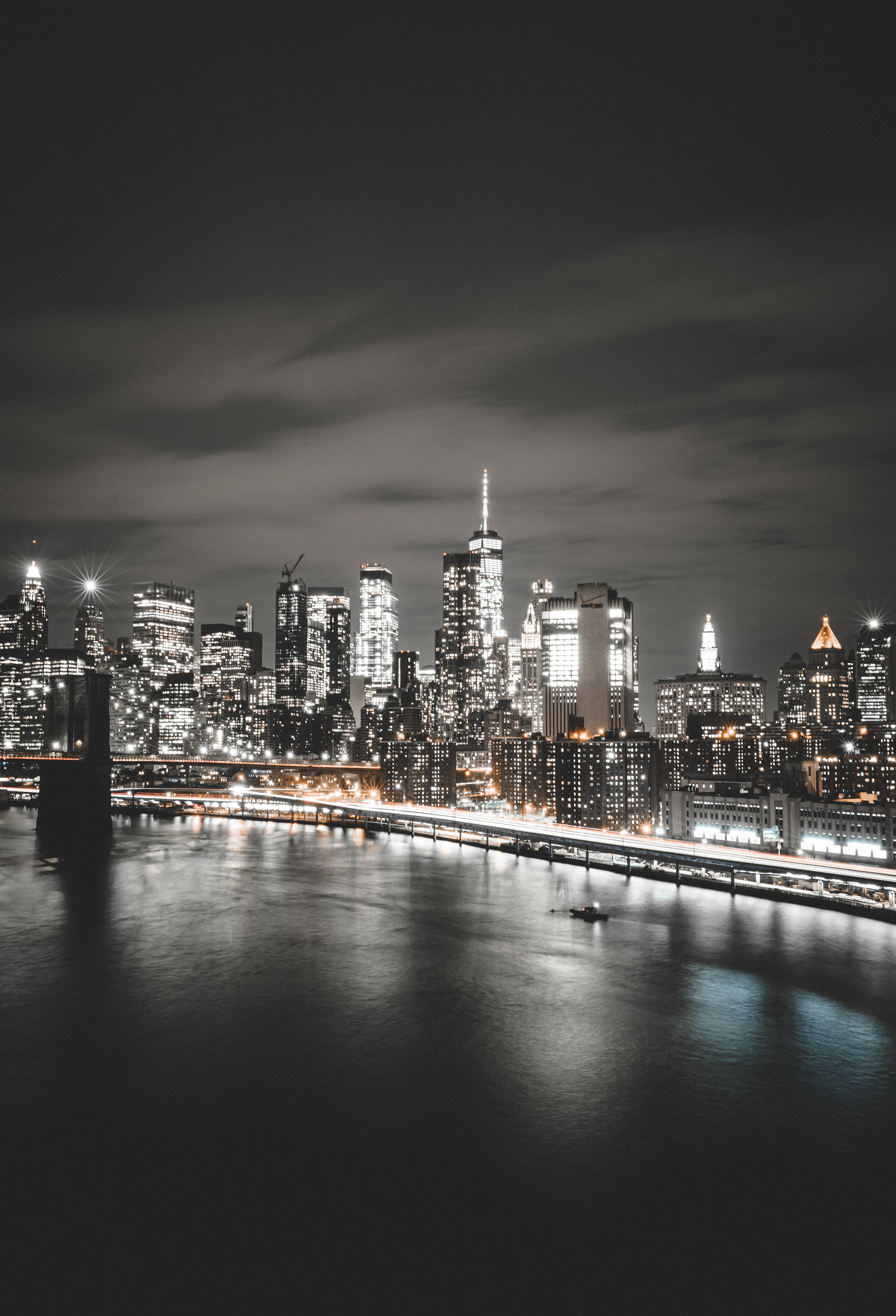 A city skyline at night with the river in the foreground - New York
