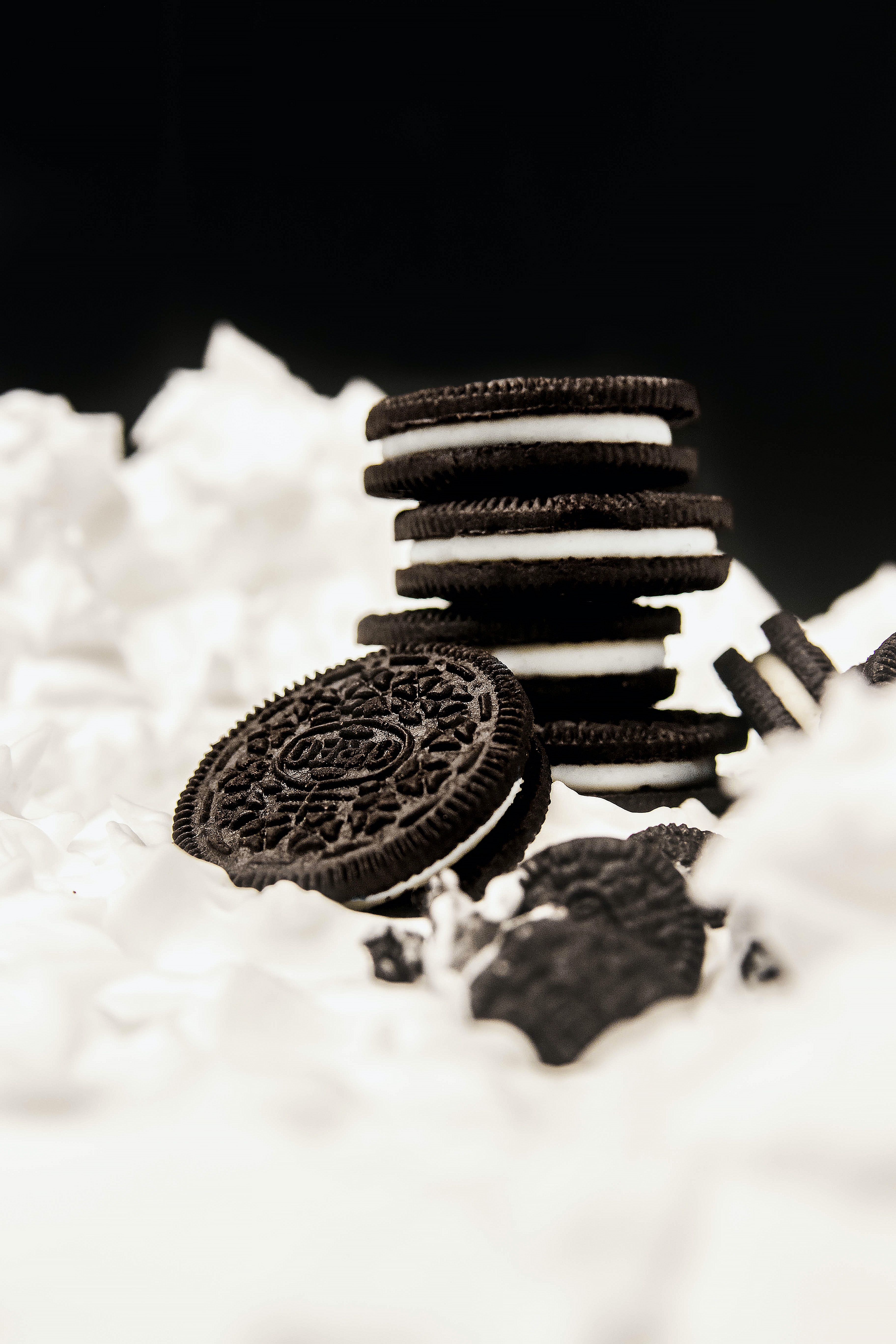 A black and white photo of a pile of Oreo cookies on a white background. - Oreo