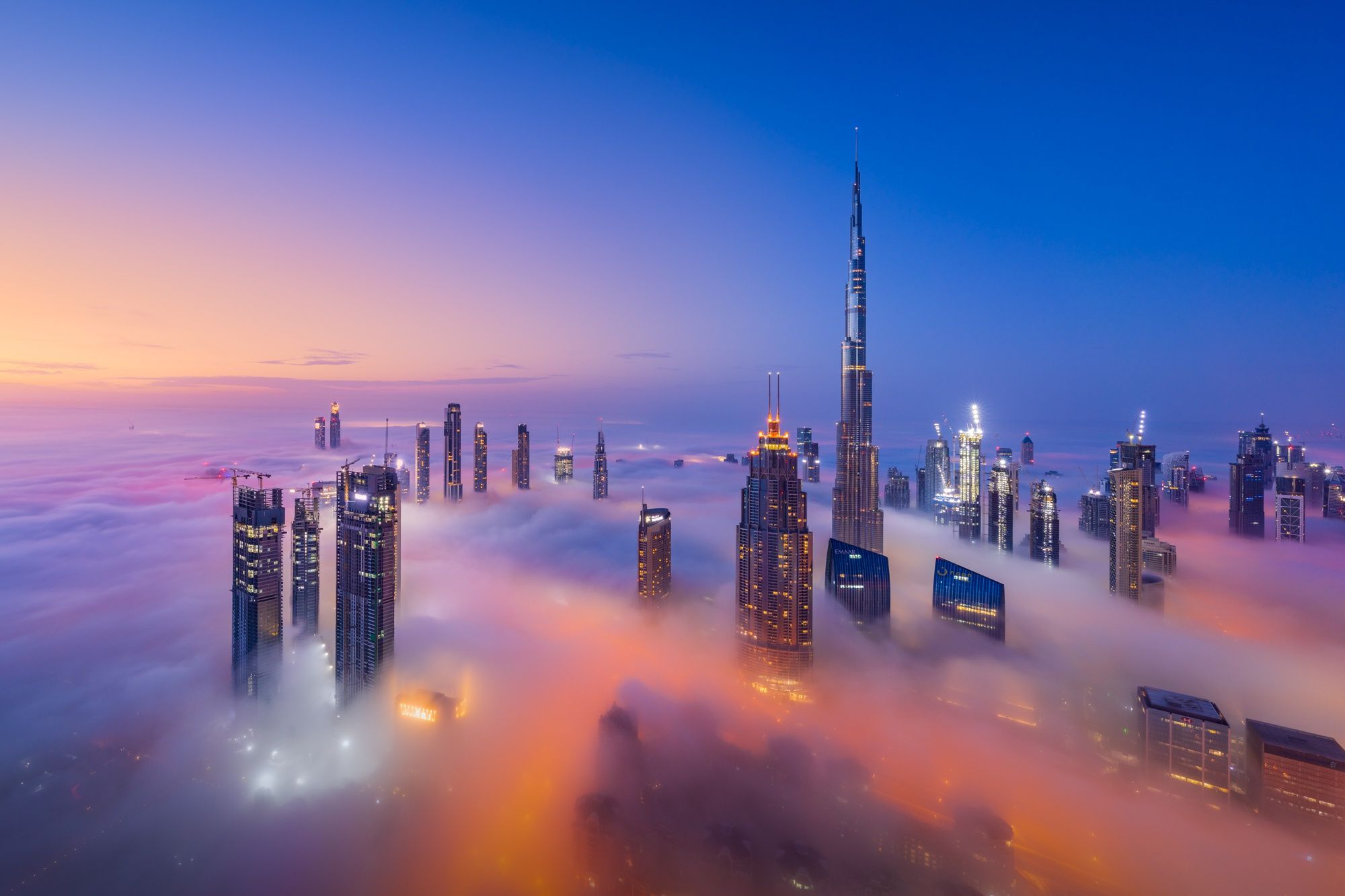 The Burj Khalifa and other buildings in Dubai are seen above the clouds. - Dubai