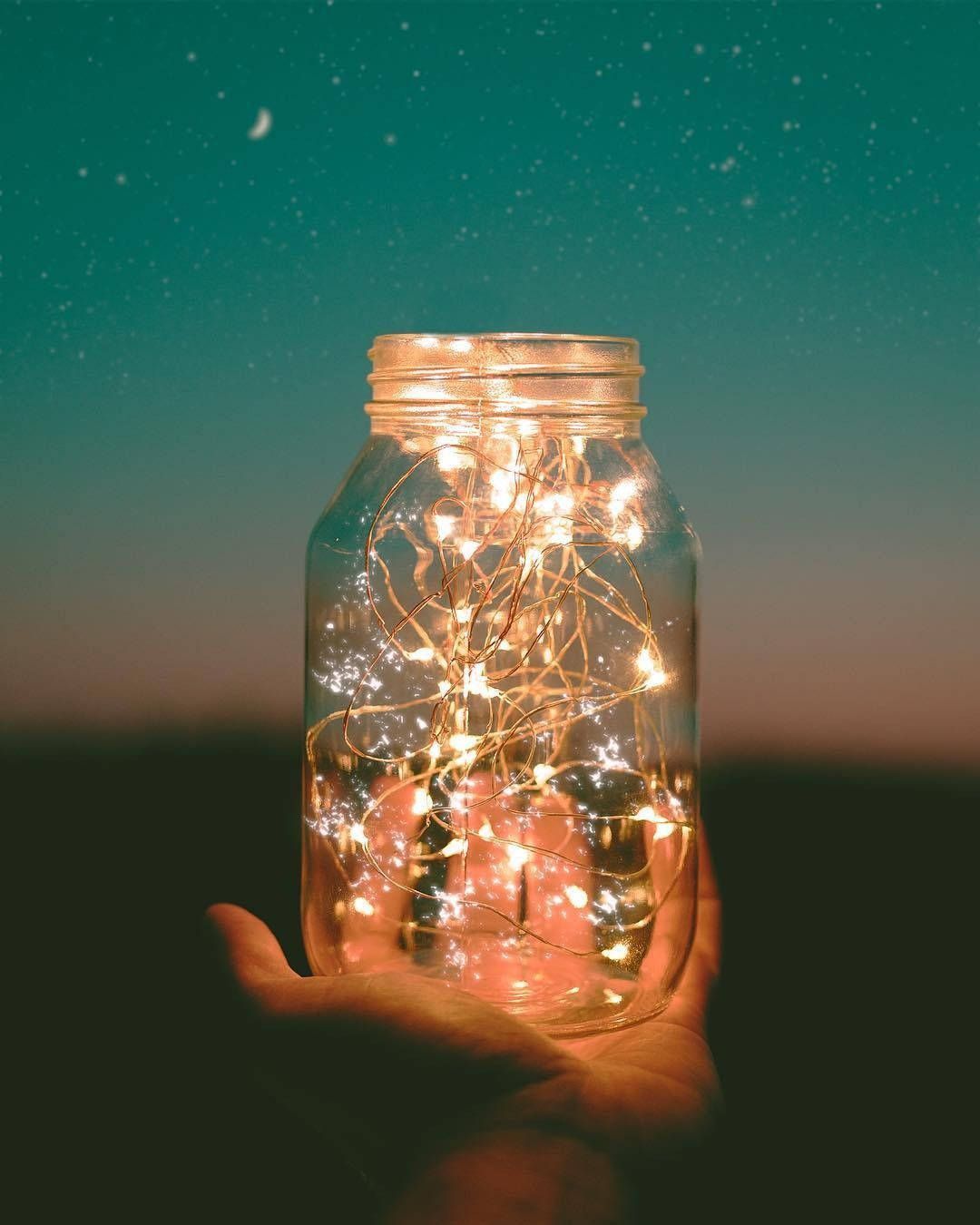 A hand holding a jar with lights inside. - Fairy lights
