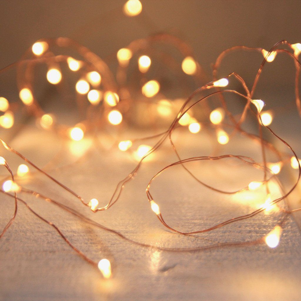A string of lights on a white surface. - Fairy lights