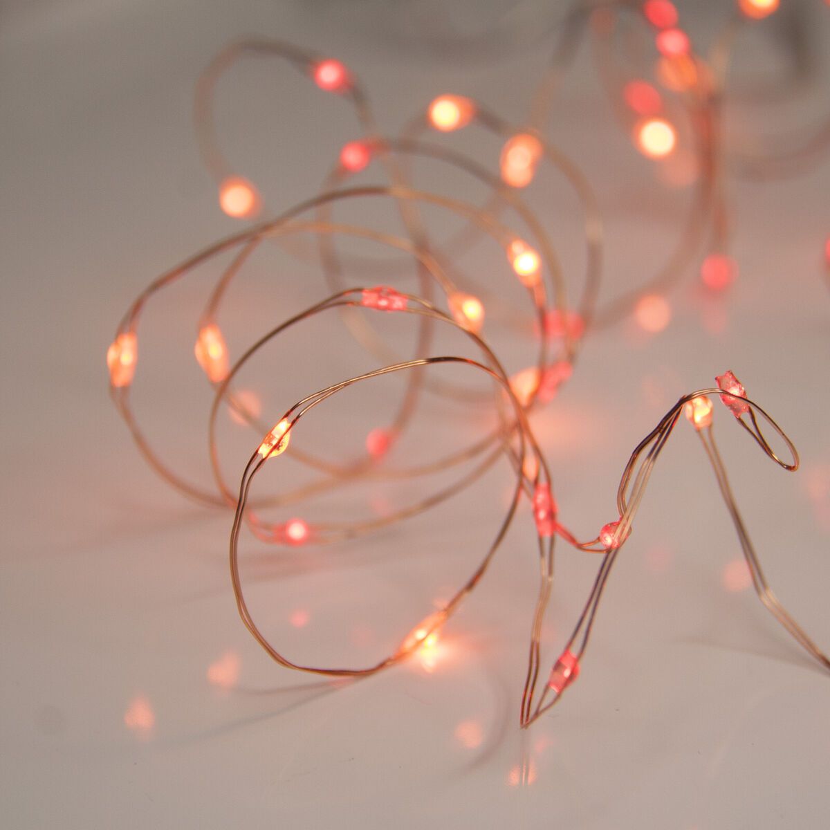 A string of red fairy lights on a white background. - Fairy lights
