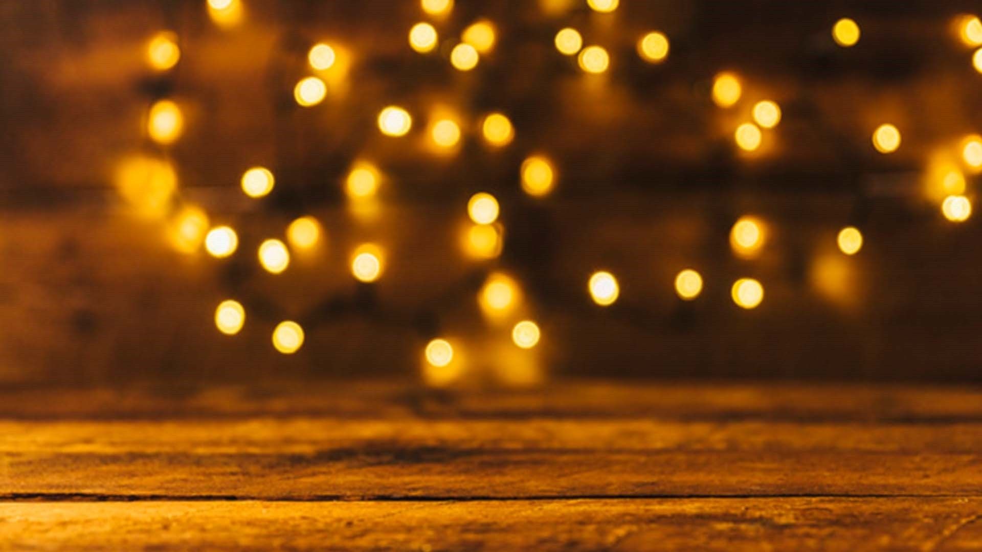 A wooden table with a blurred background of fairy lights. - Fairy lights