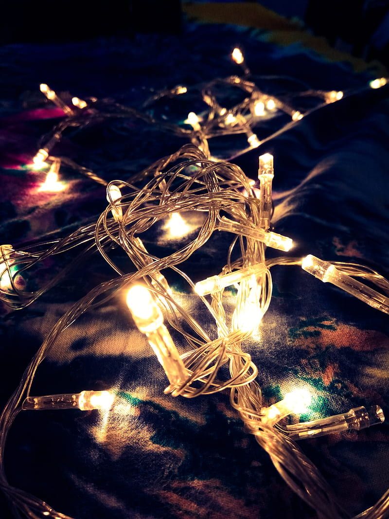 A string of fairy lights on a bed. - Fairy lights