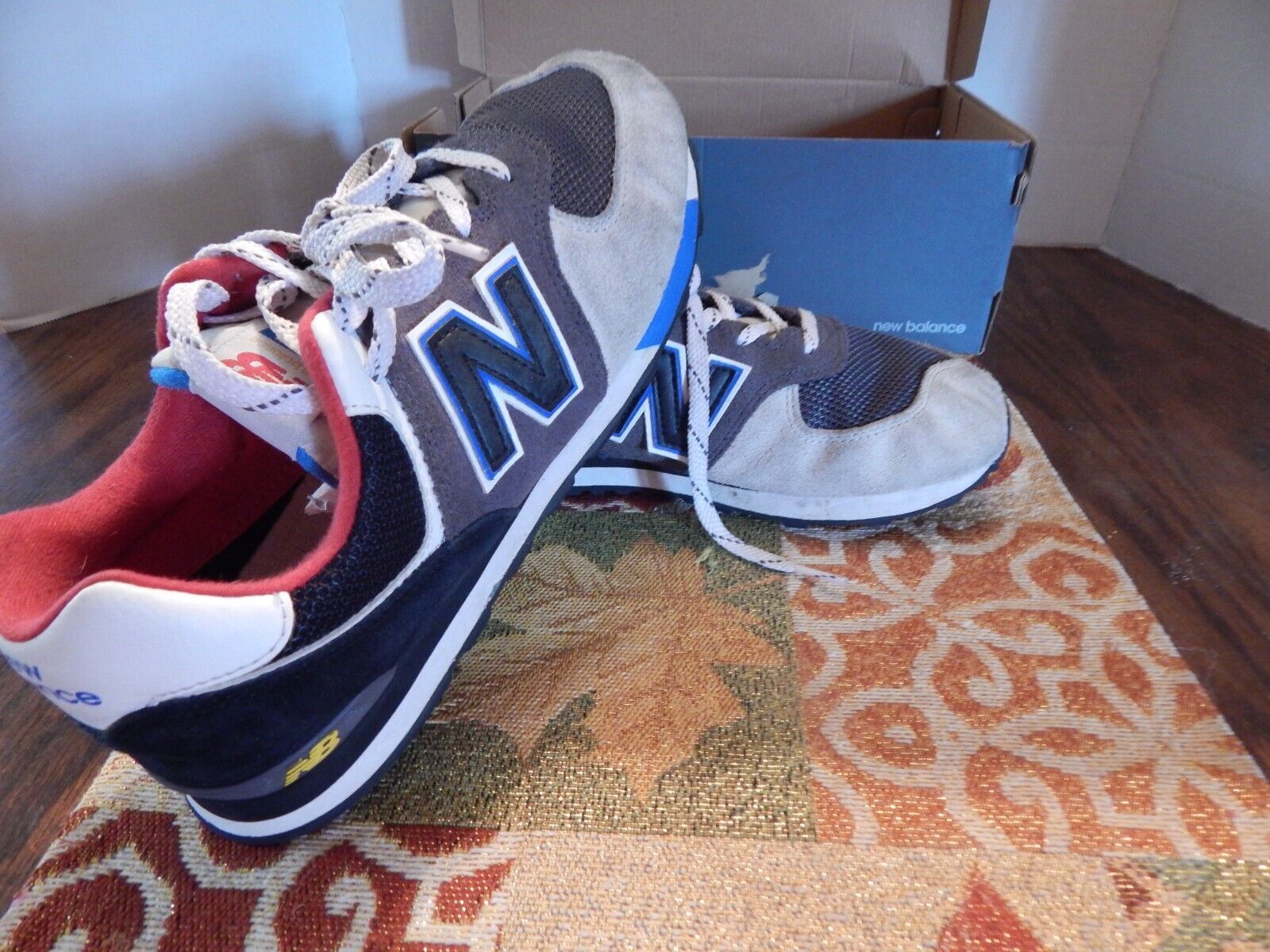 A pair of new balance shoes on a rug. - New Balance