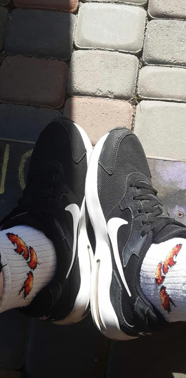 Black and white Nike shoes with socks that have flames on them - Shoes