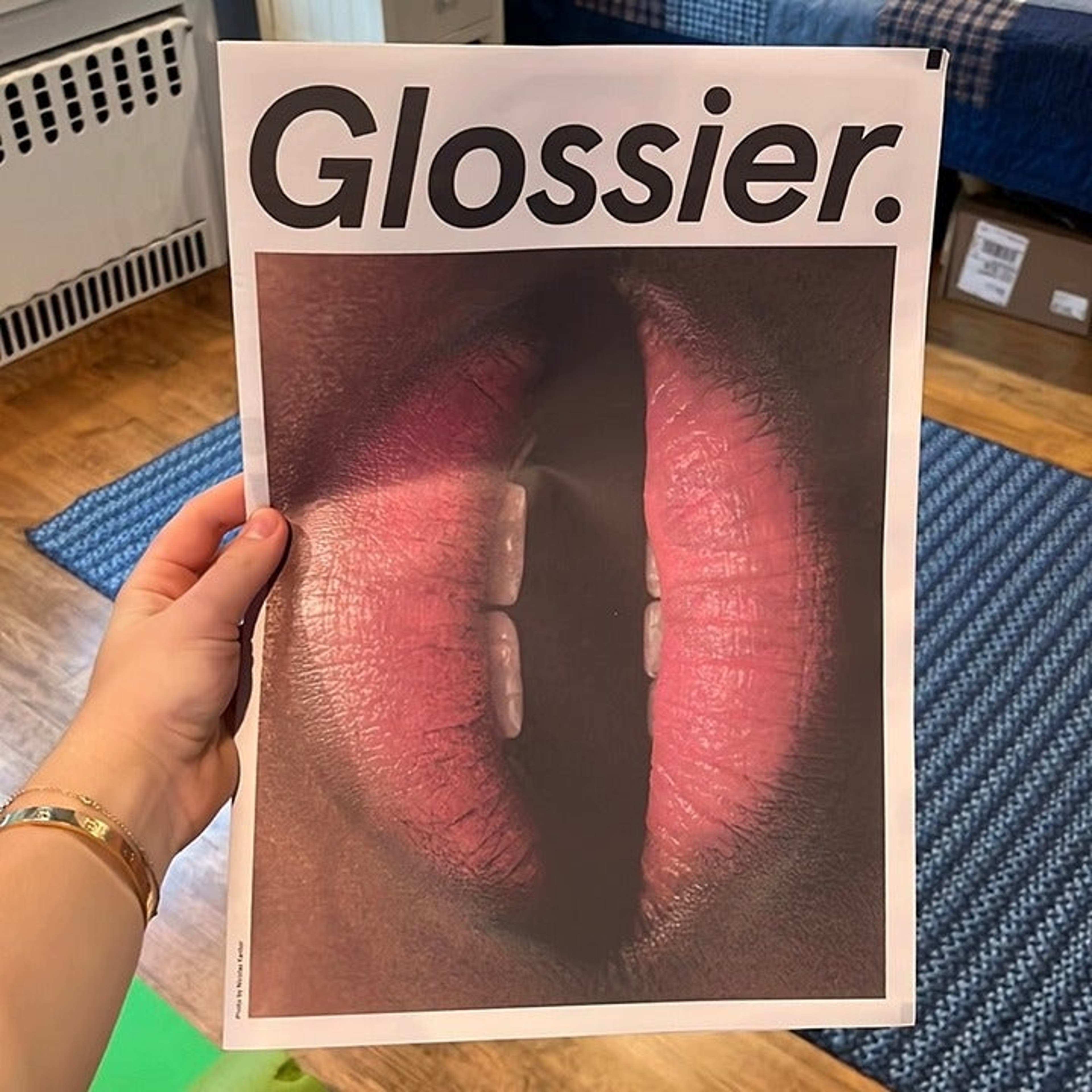 A person holding a Glossier magazine in their hand. - Lips