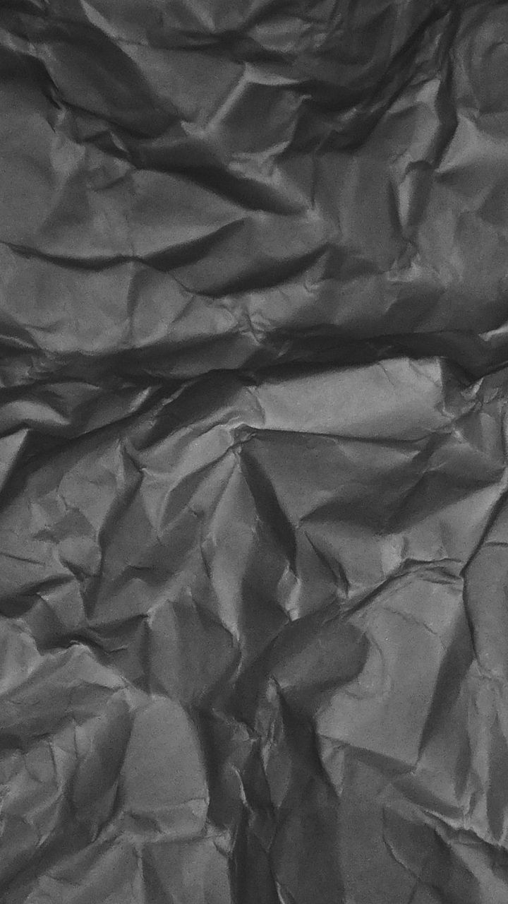 A black and white photo of a crumpled piece of black paper - Paper