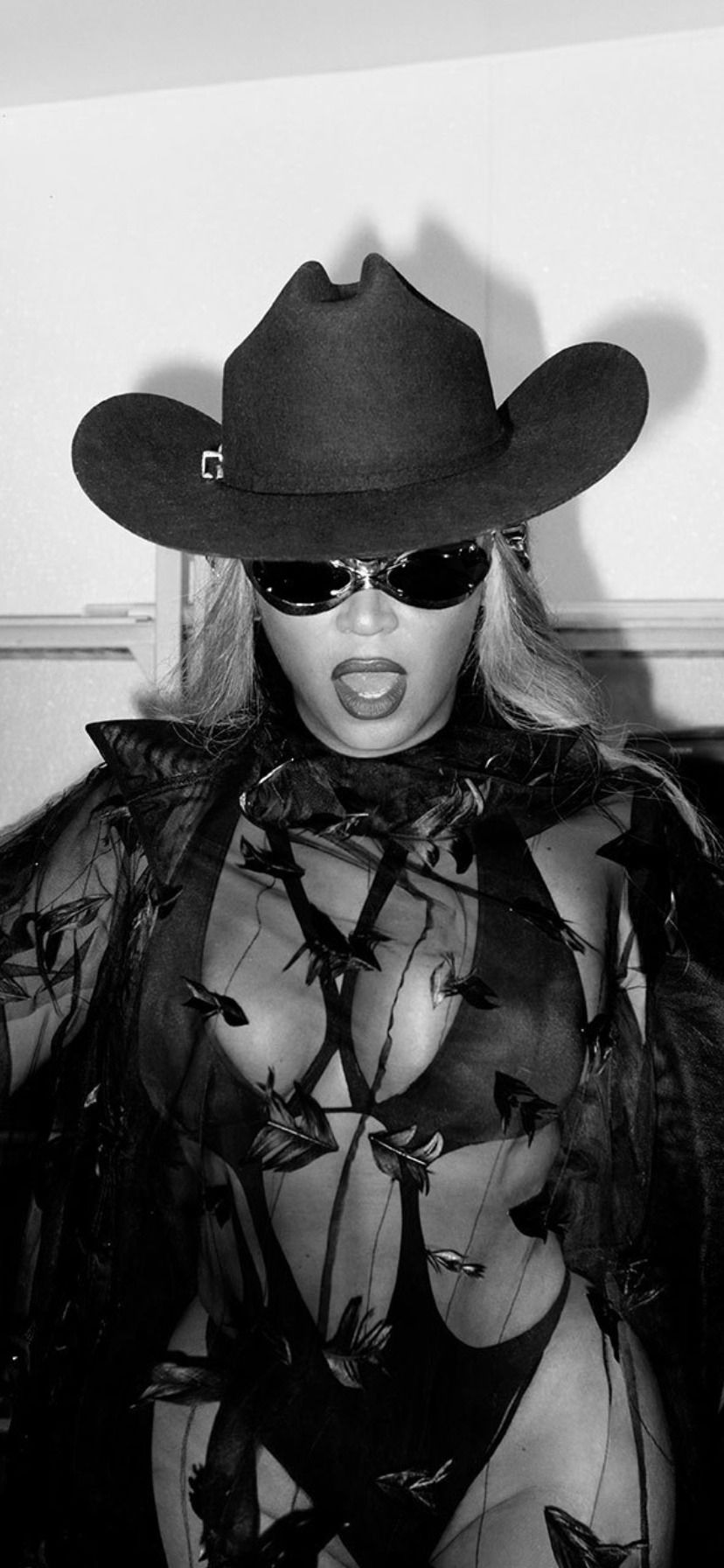 A woman in black and white clothing wearing sunglasses - Beyonce