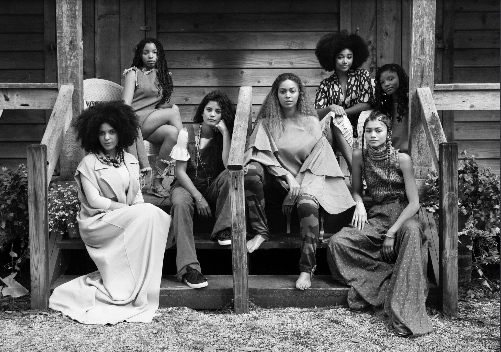 A group of women sitting on the steps in front - Beyonce