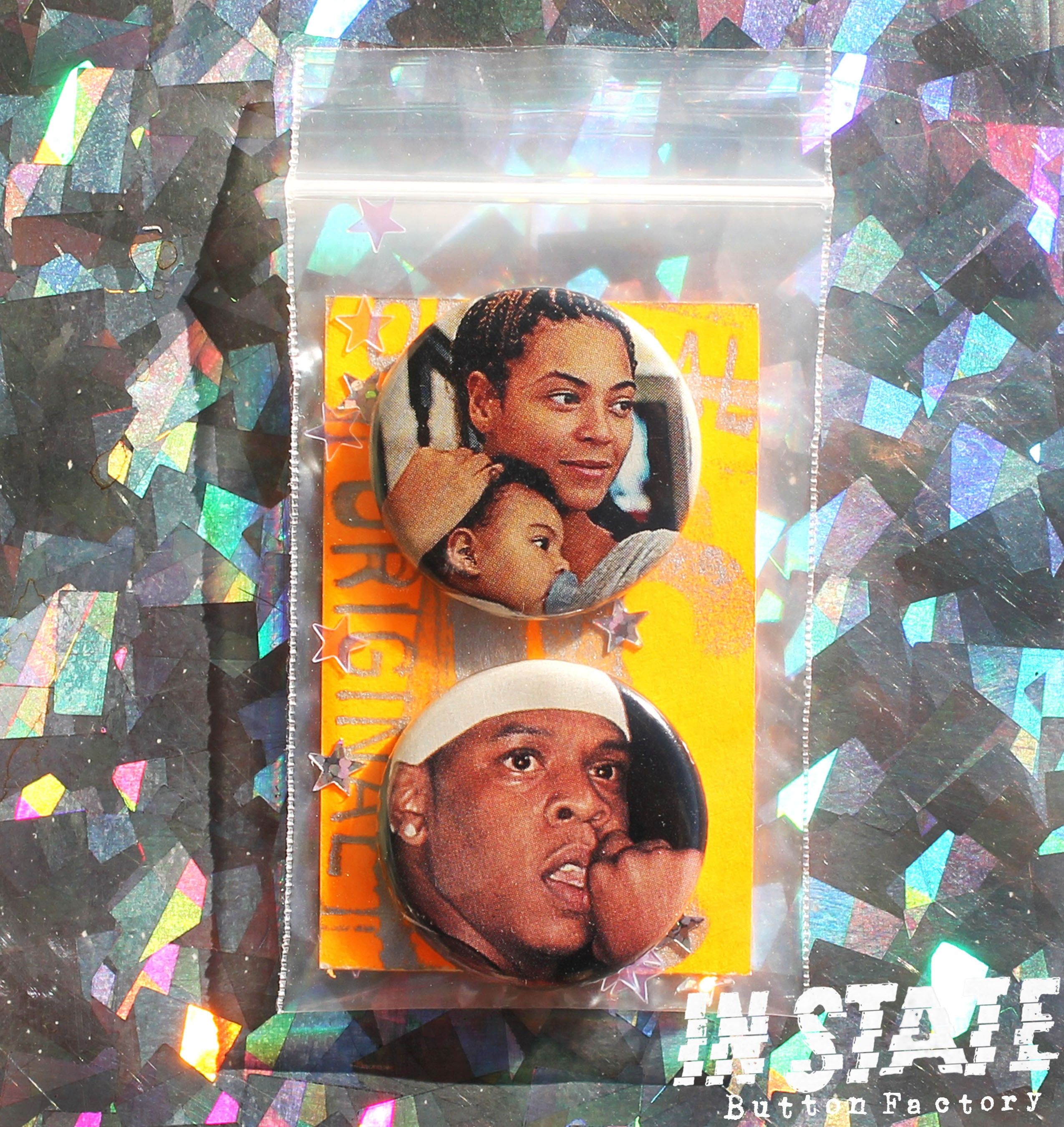 A set of two buttons in a plastic bag. The top button has a photo of Beyoncé holding her head to her chest, and the bottom button has a photo of Jay-Z with his tongue out. - Beyonce