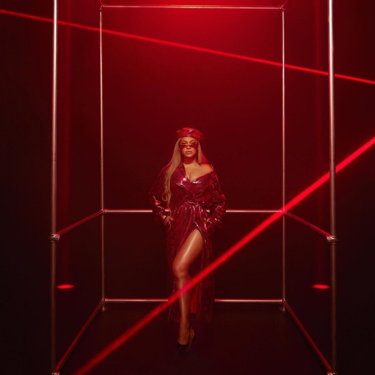 Beyoncé in a red dress standing in a red-lit room - Beyonce