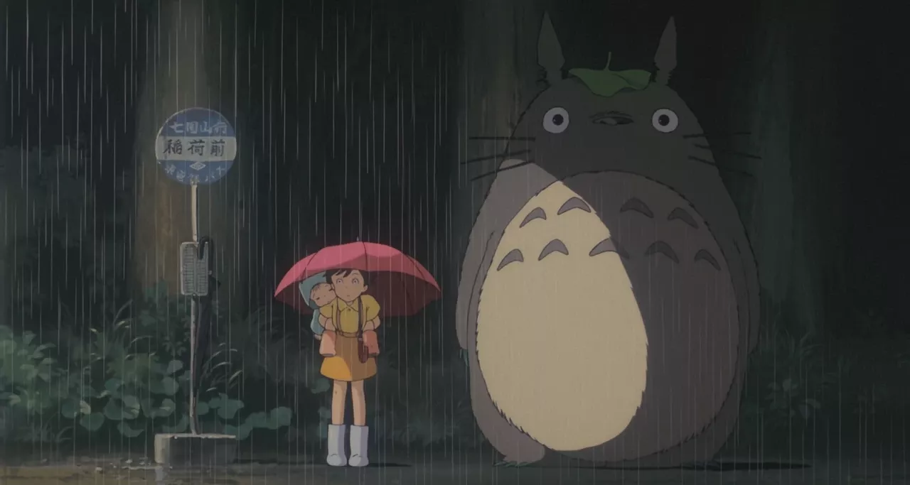 Screenshot from My Neighbor Totoro, a girl and a giant cat standing under a rain shower - My Neighbor Totoro
