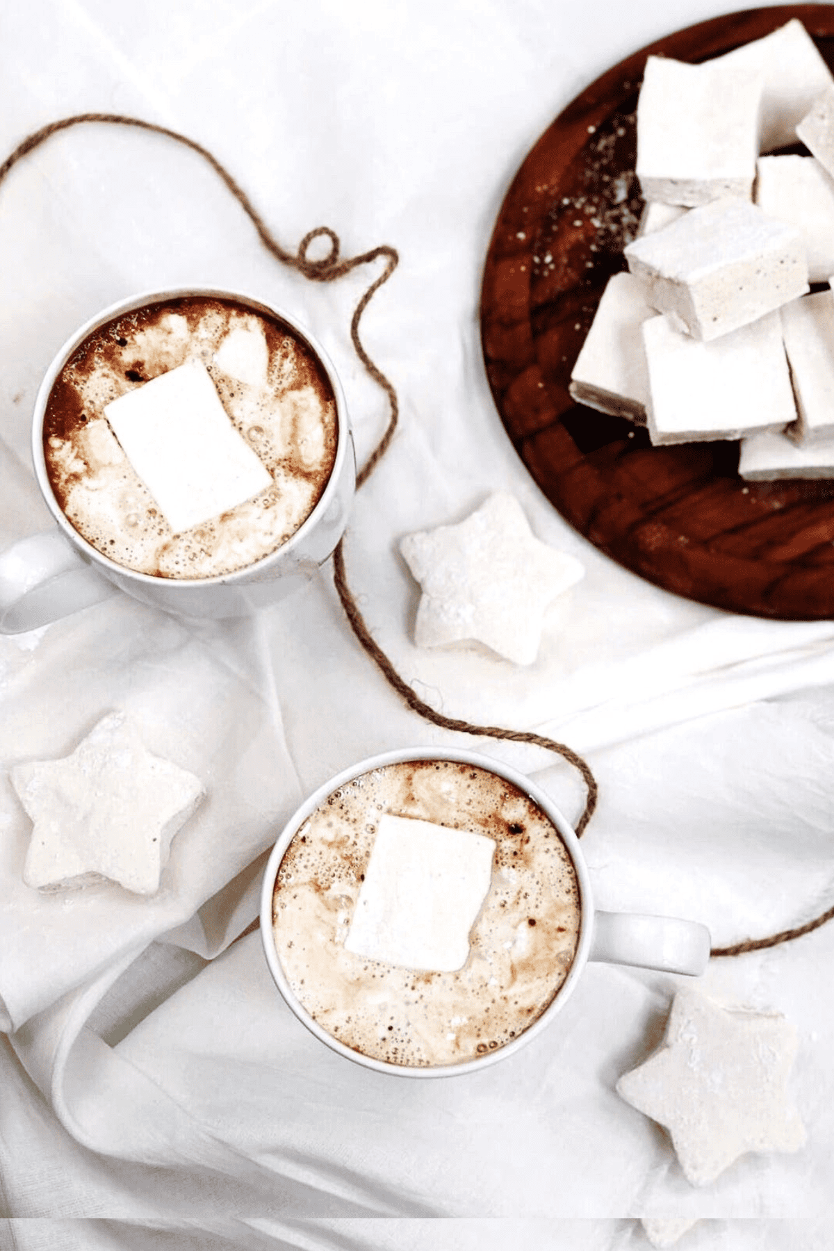 Two cups of hot chocolate with homemade marshmallows on a white tablecloth. - Marshmallows