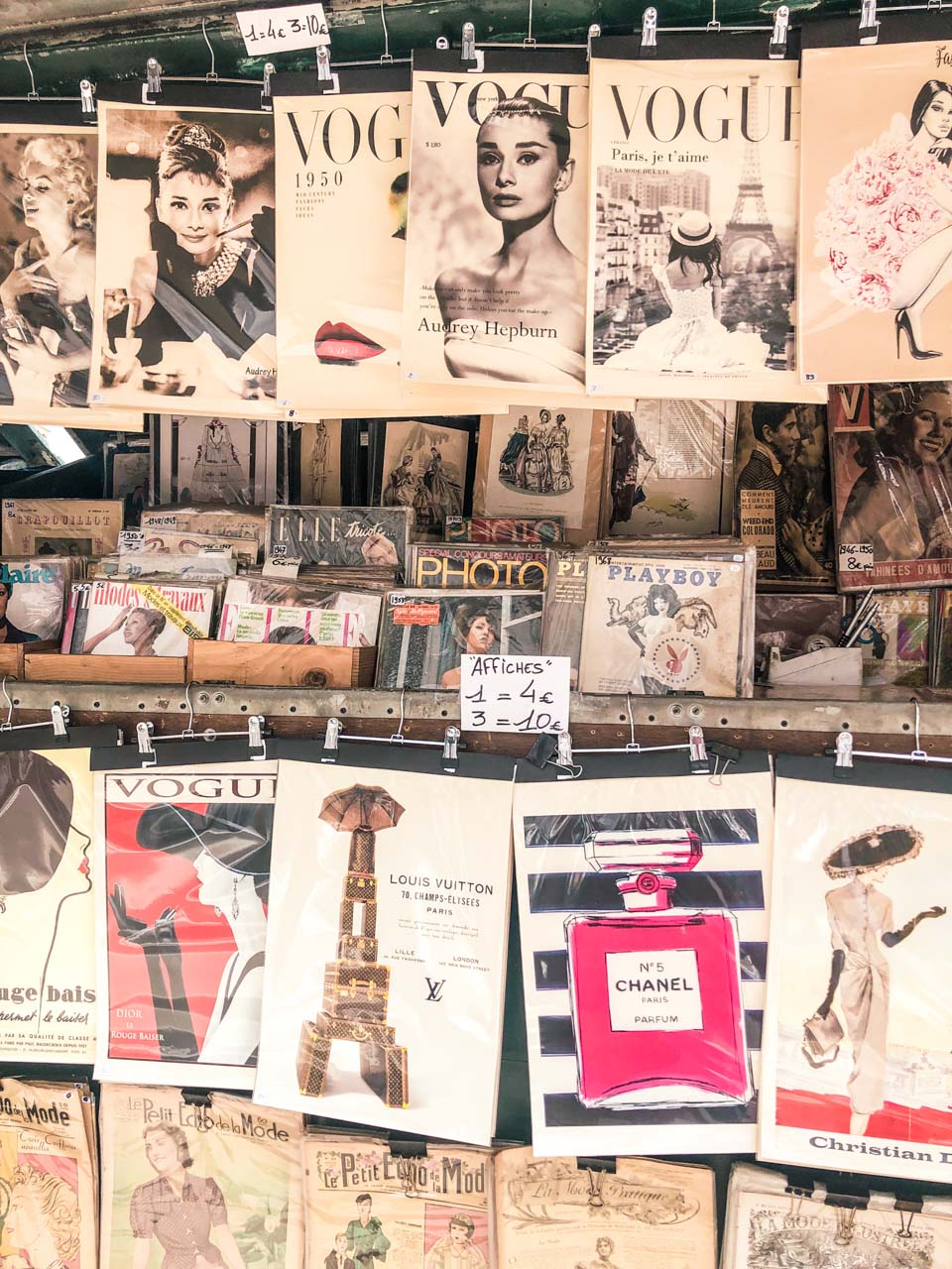 A wall of magazines and books on display for sale. - Vogue