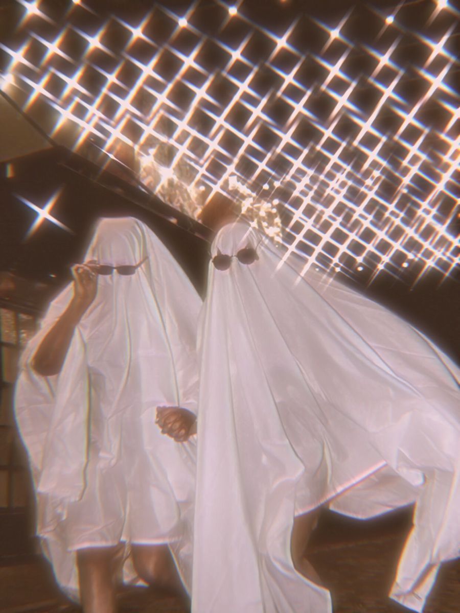 Two people in white sheets standing under a disco ball - Ghost