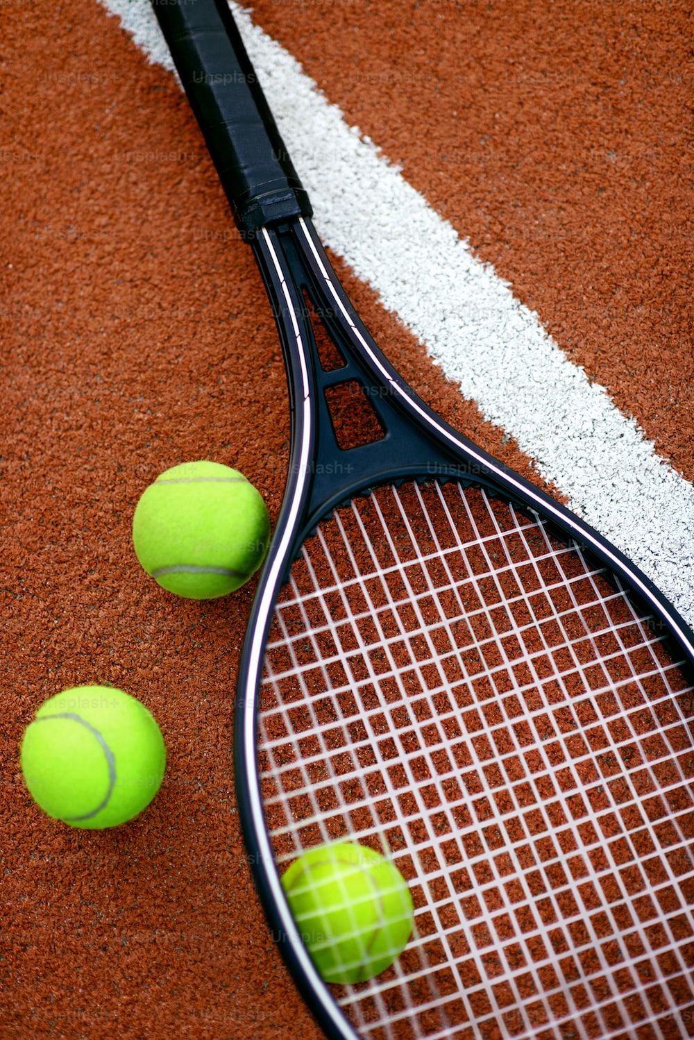 Close up of a tennis racquet and balls on a tennis court - Tennis