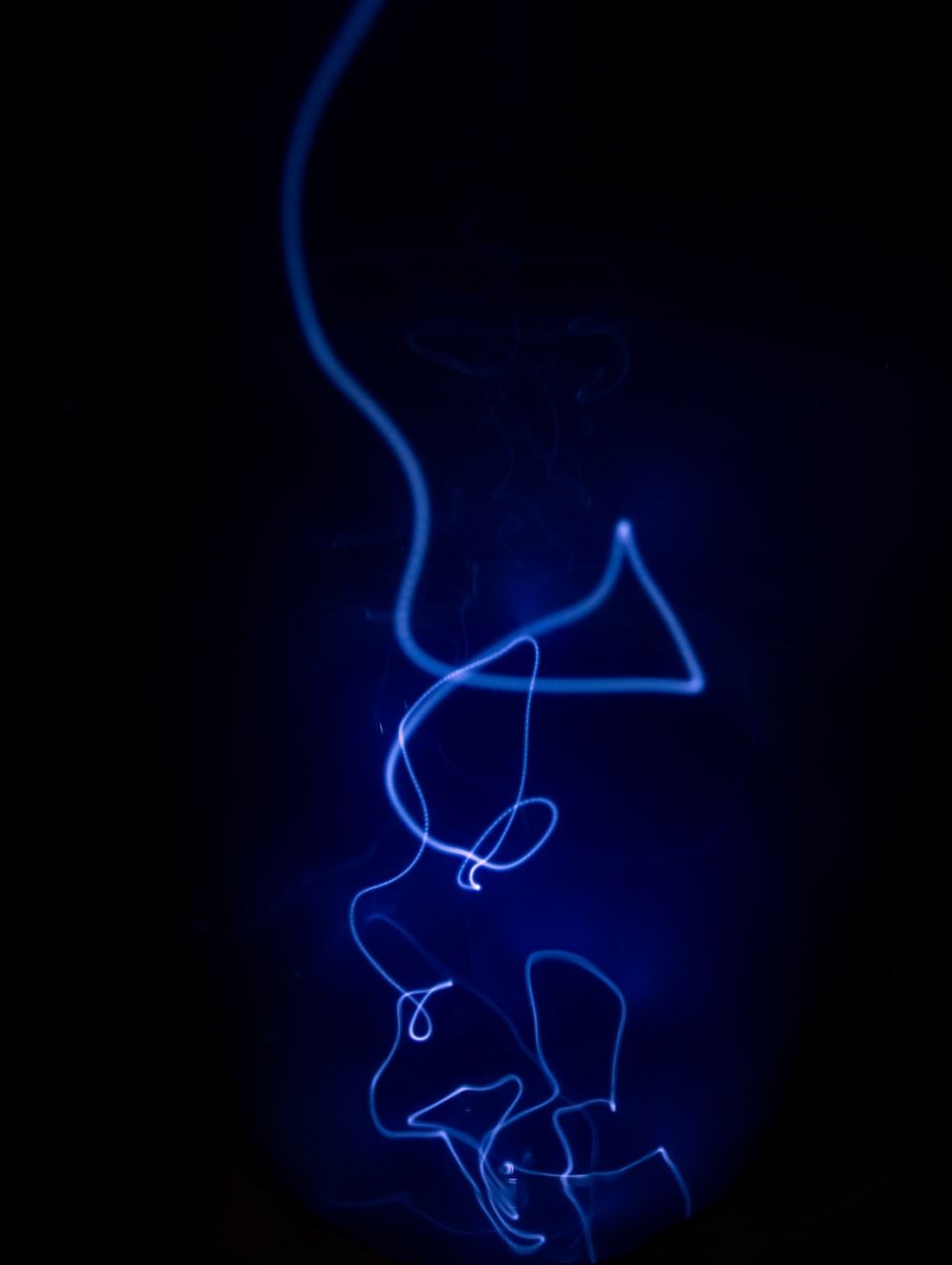 A blue light is shining on a black background photo