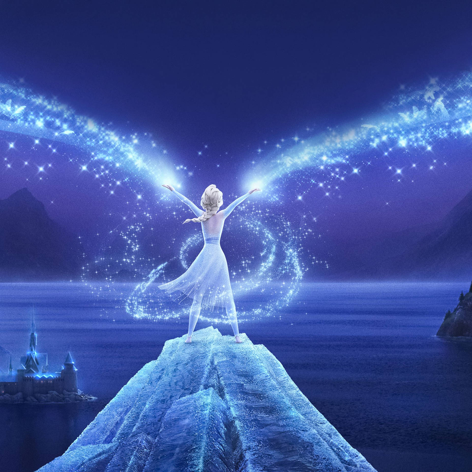 Elsa from Frozen standing on a mountain with her arms outstretched, surrounded by magic - Elsa