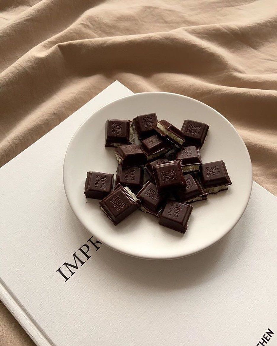 A plate of chocolate squares on top of a book - Chocolate