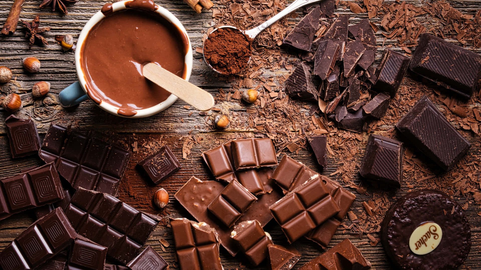 A cup of hot chocolate surrounded by chocolate bars and chocolate powder - Chocolate