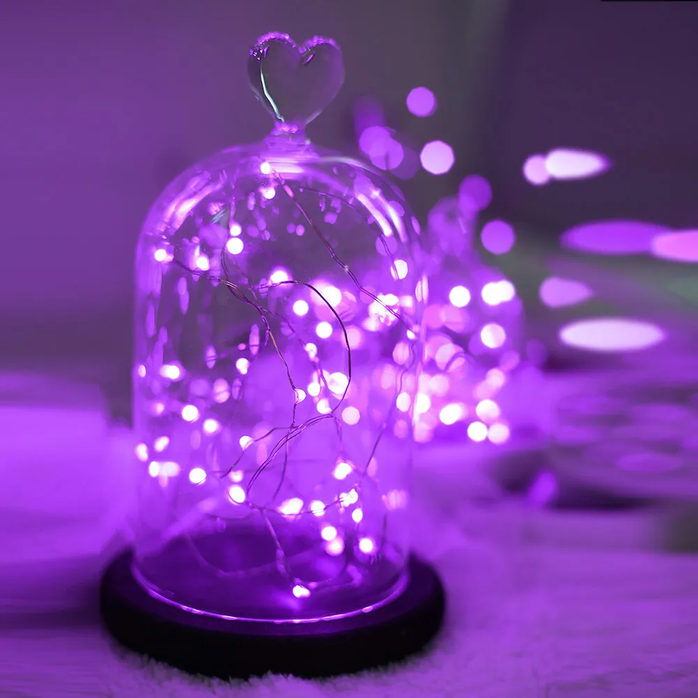 Purple fairy lights in a glass dome on a white fluffy blanket. - Fairy lights