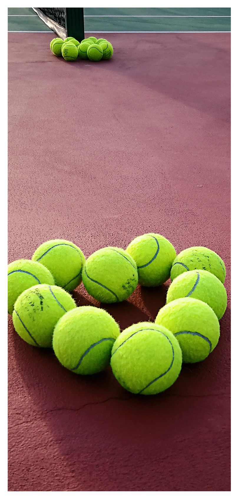 A group of tennis balls on the ground - Tennis