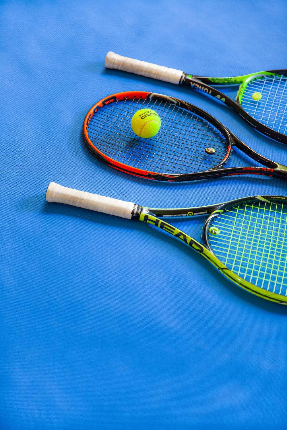 A tennis racket and ball on blue surface - Tennis