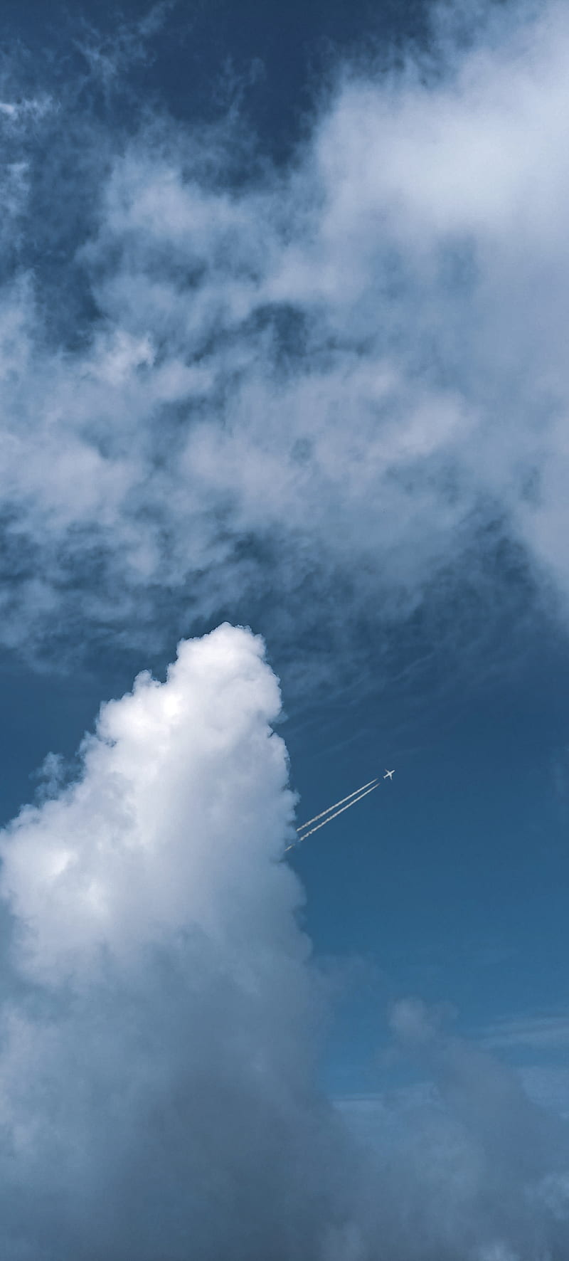 An airplane flying through the sky with clouds - Android