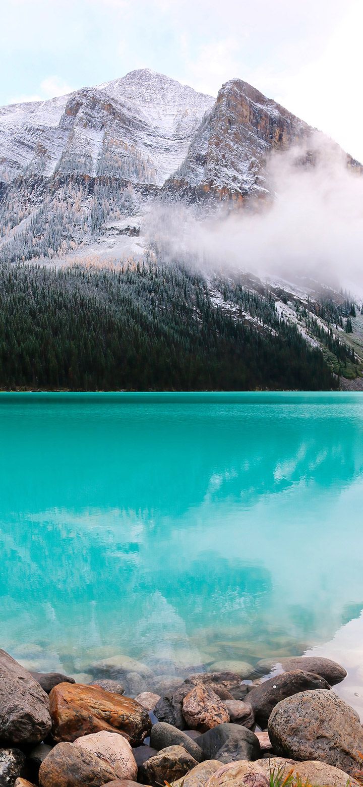 A lake surrounded by snow capped mountains - Turquoise