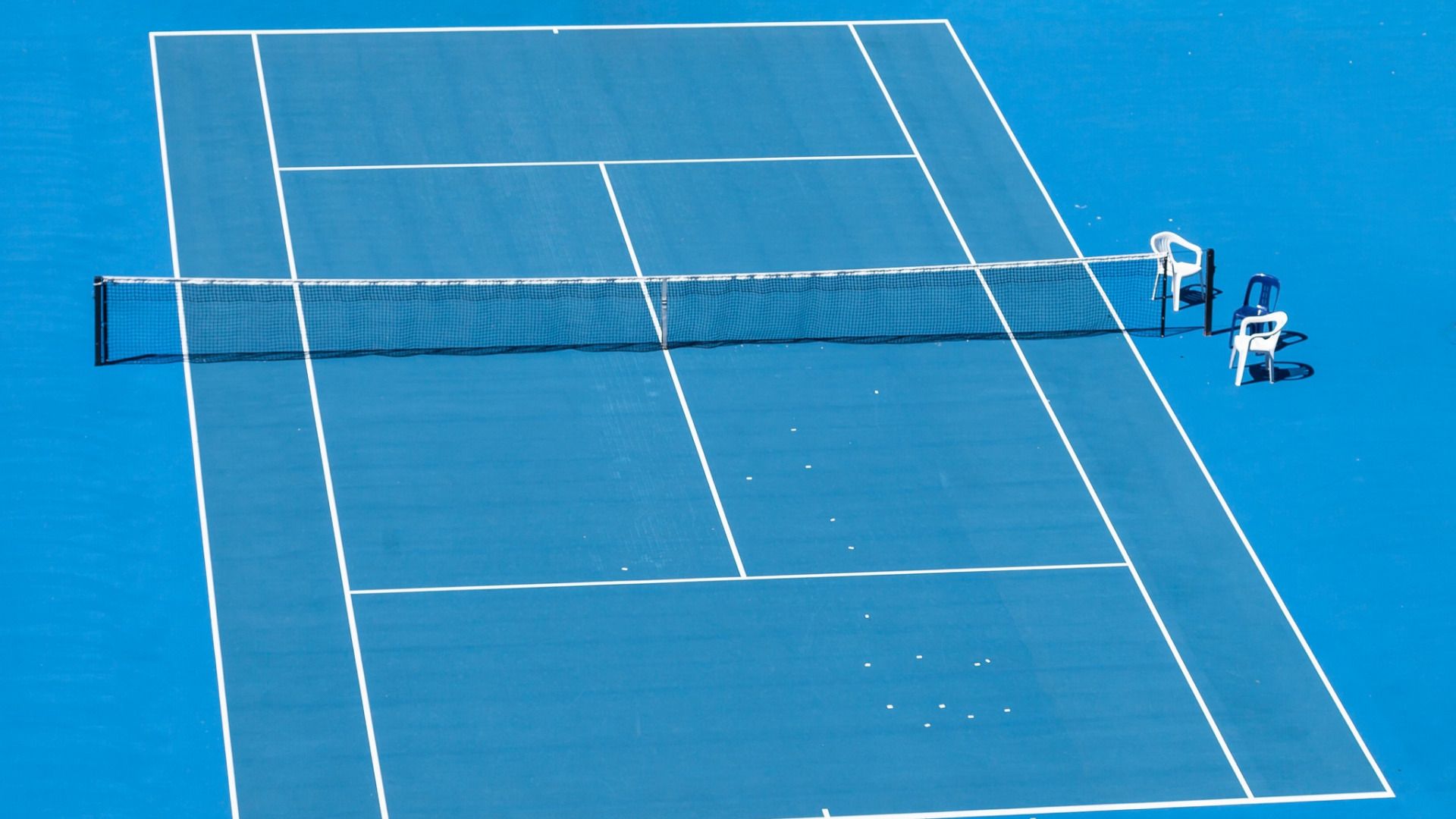 A tennis court with chairs on it - Tennis