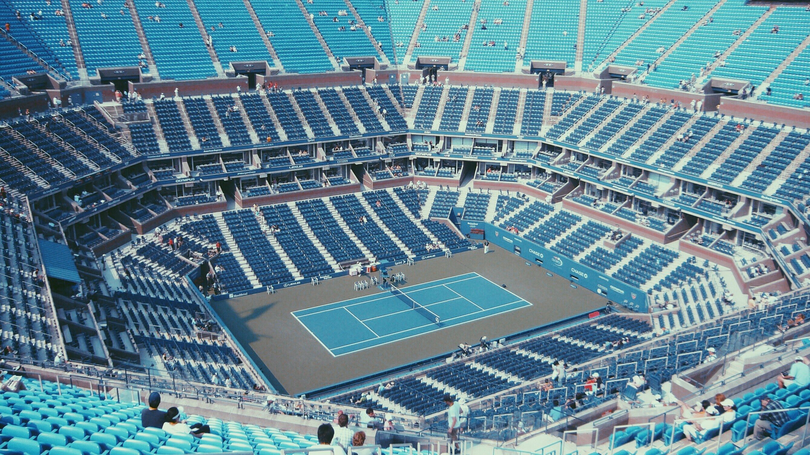 A tennis court with many people sitting in the stands - Tennis