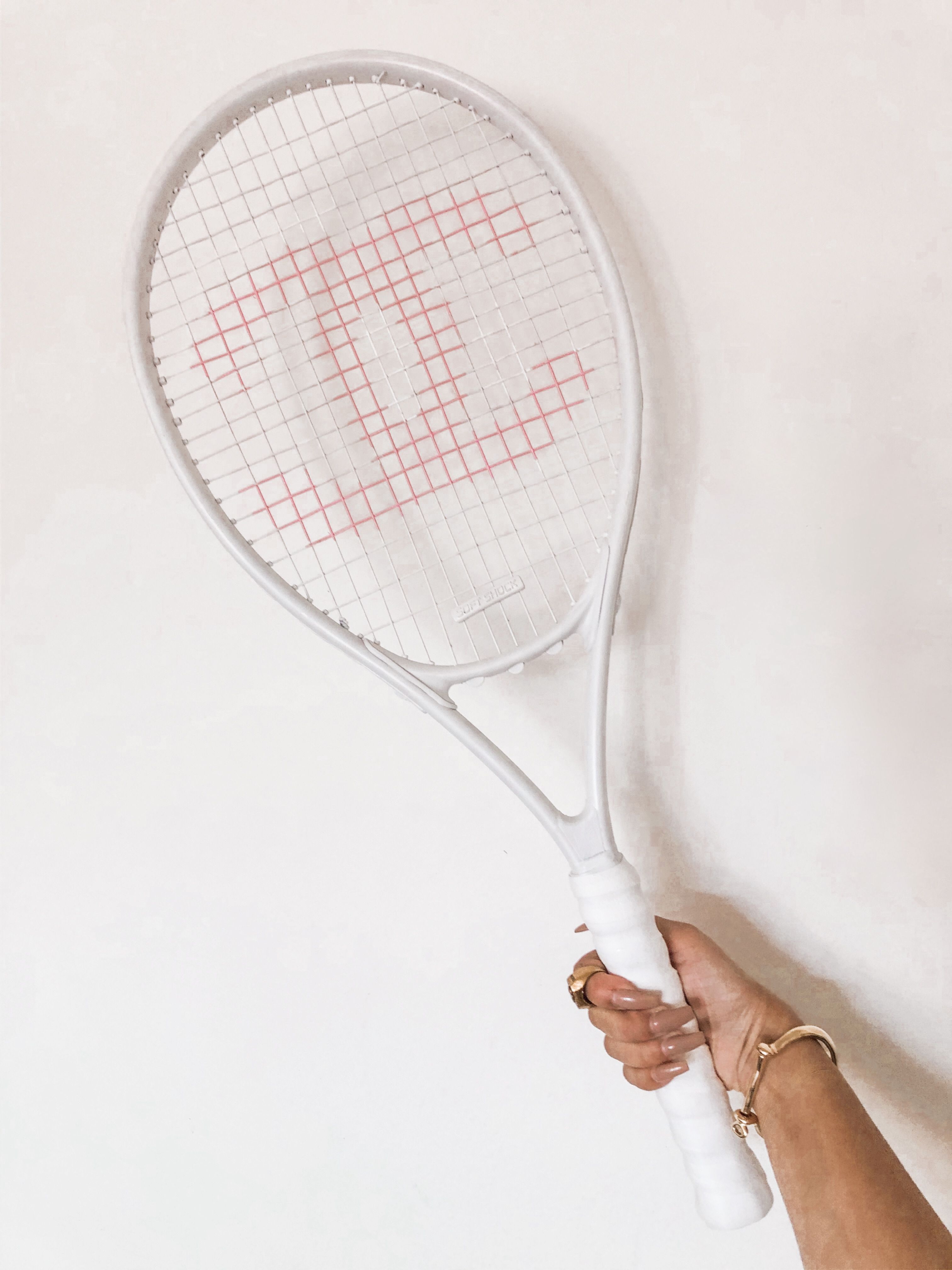 A white tennis racket with a red W on it. - Tennis