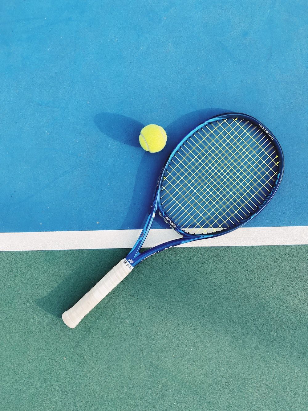 A tennis racket and ball on a tennis court - Tennis