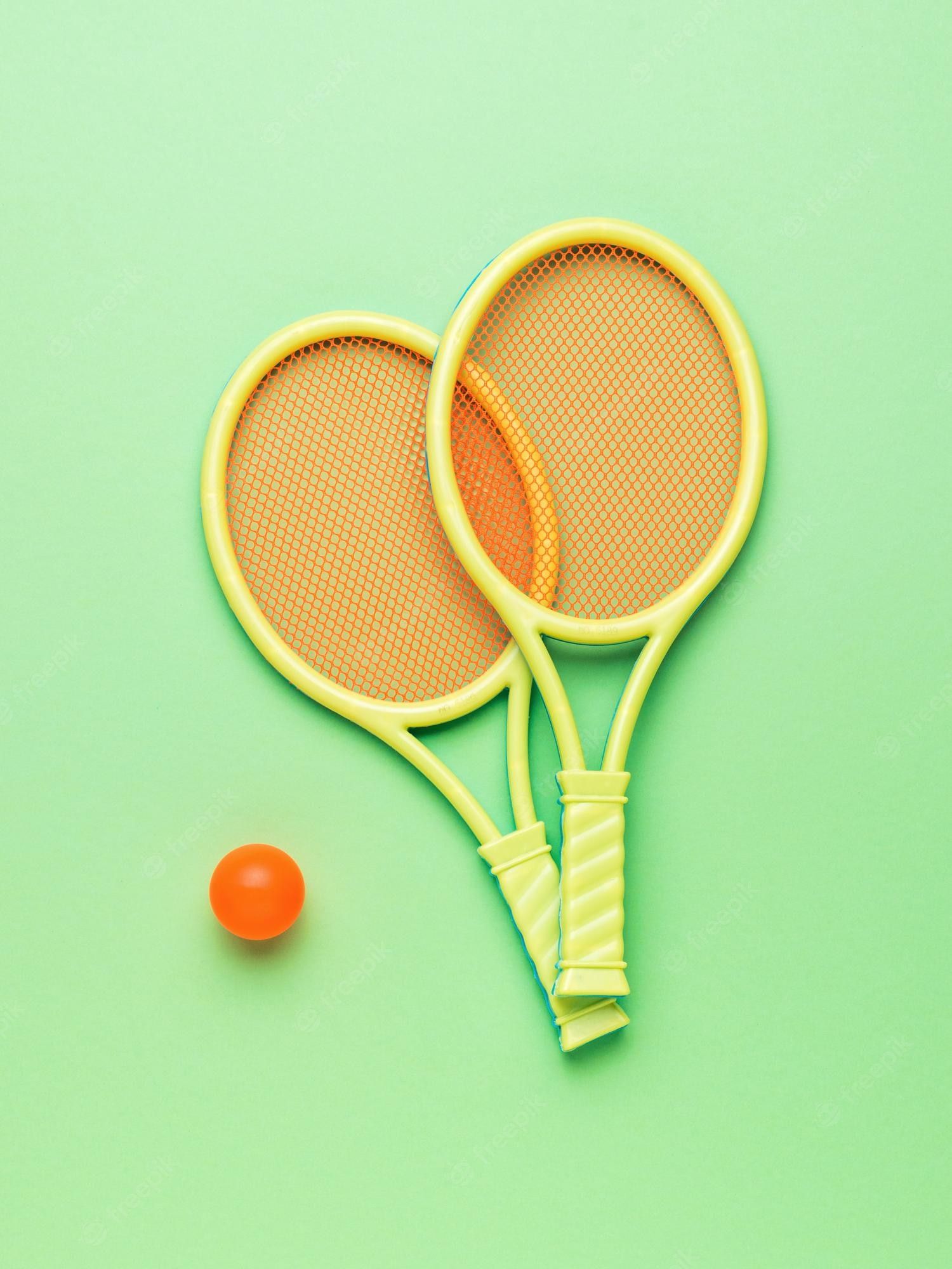 A pair of tennis rackets and an orange ball - Tennis