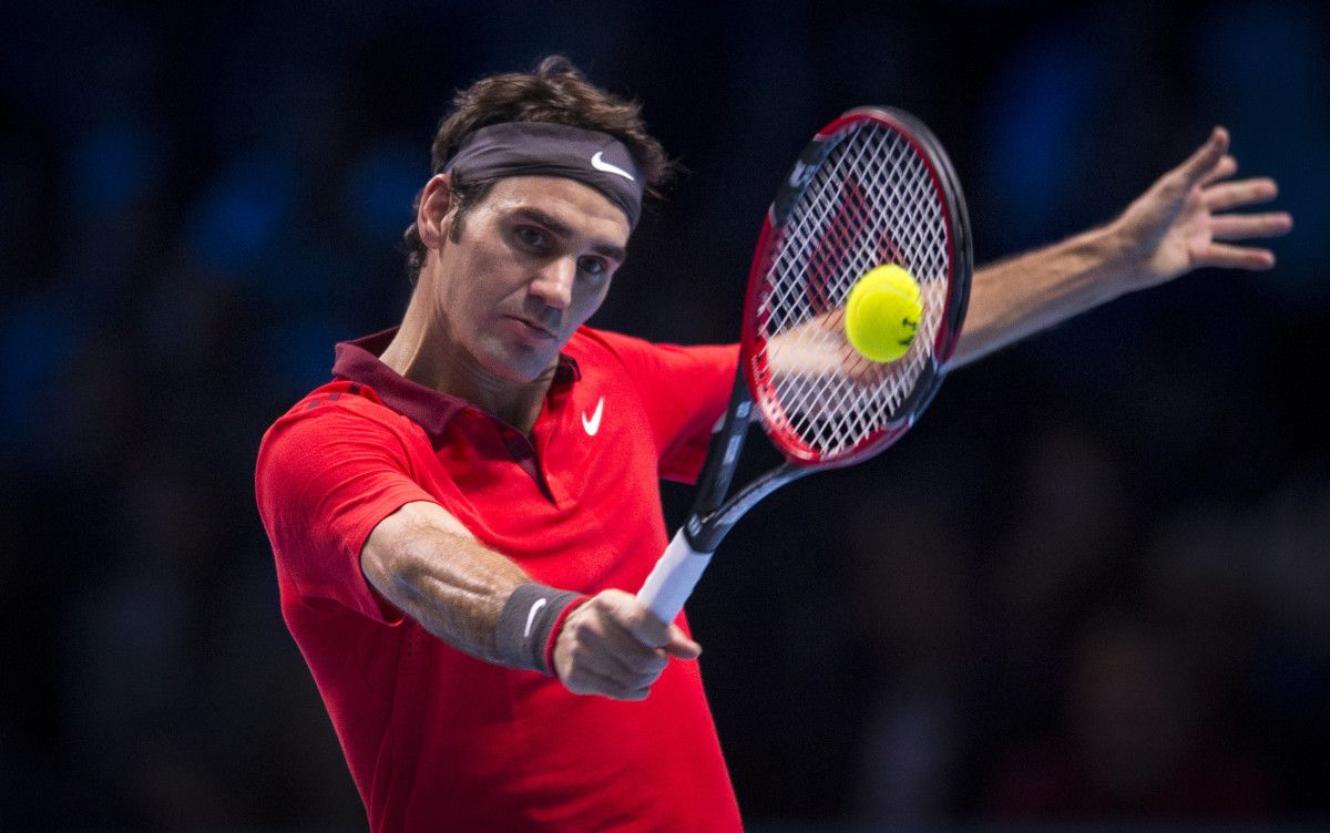 Roger Federer of Switzerland returns the ball to Kei Nishikori of Japan during their round-robin match at the ATP World Tour Finals tennis tournament at the O2 Arena in London, Tuesday, Nov. 11, 2014. - Tennis