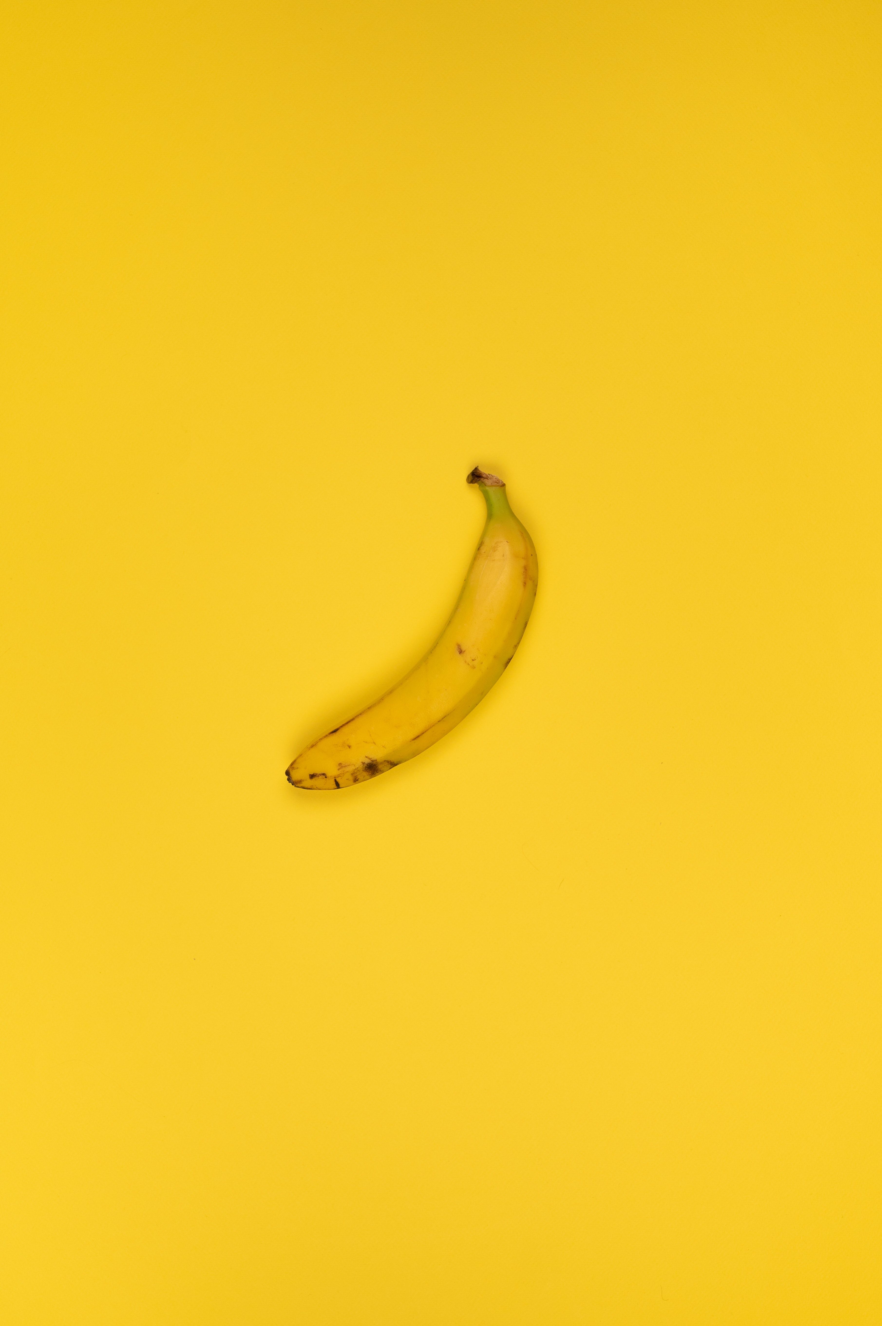 A single banana on a yellow background - Banana