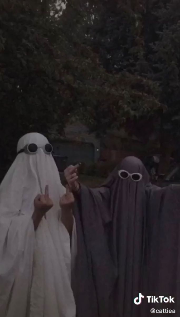 Two people in ghost costumes with white sheets over their heads and sunglasses on their faces. - Ghost